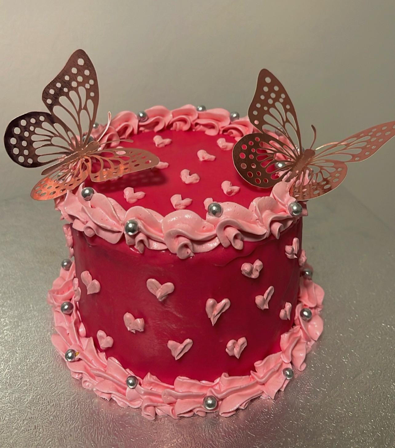 Deep pink cake with butterflies and piped hearts